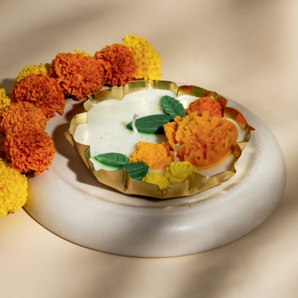 Festival Bloom — a hand-poured lotus urli candle adorned with marigold blooms, crafted to brighten your festive rituals with warmth and grace.